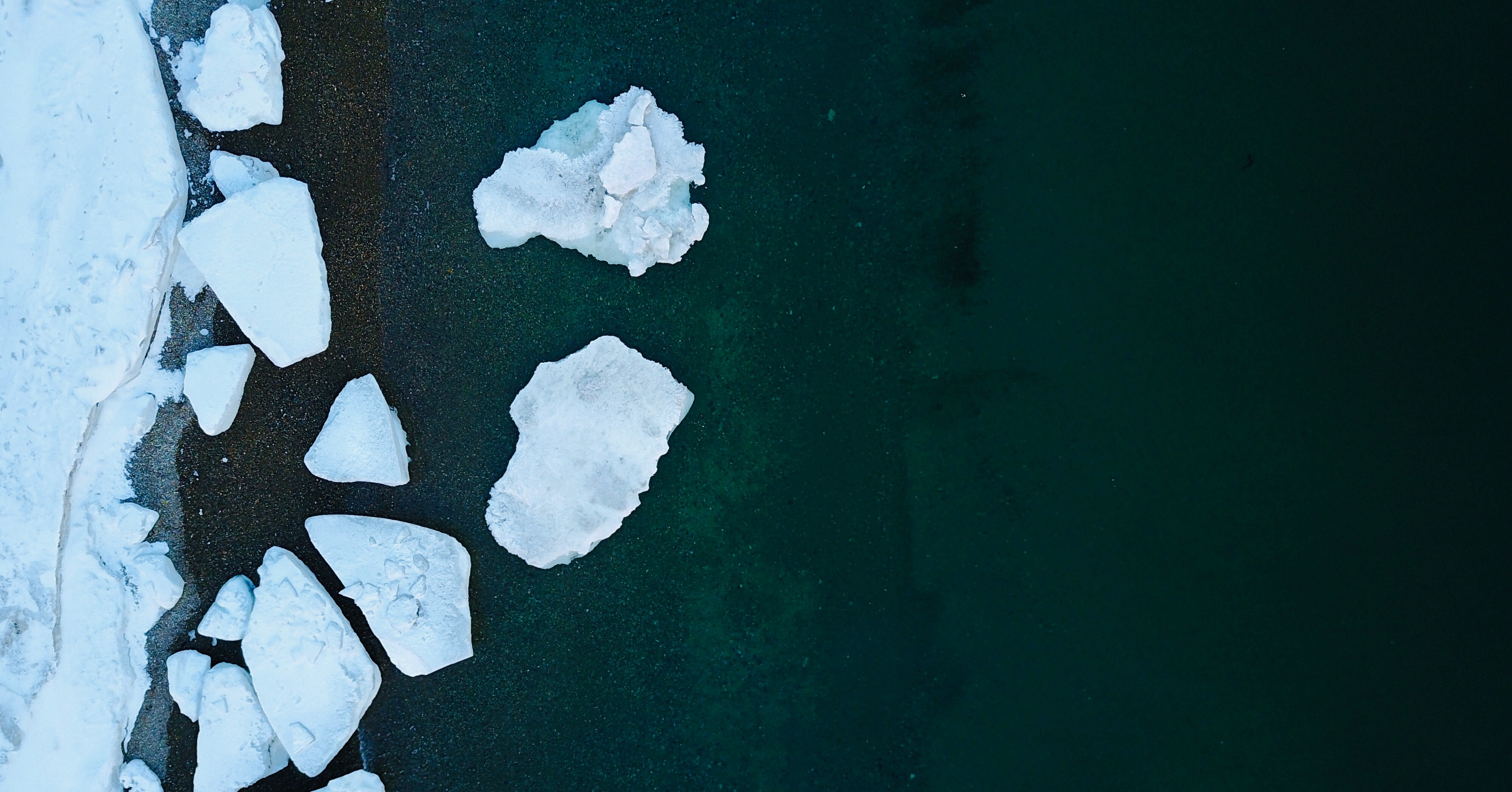 Ice islands. Человек бурит лед на озере.